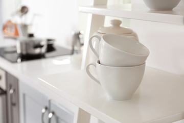 Fototapeta na wymiar Cups on shelf in modern kitchen