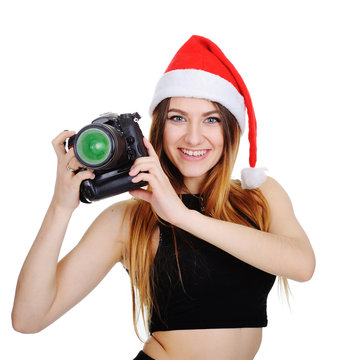 beautiful girl in a Christmas hat of Santa Claus with a digital camera on a white background