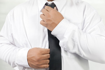 businessman in white shirt taking off neck tie