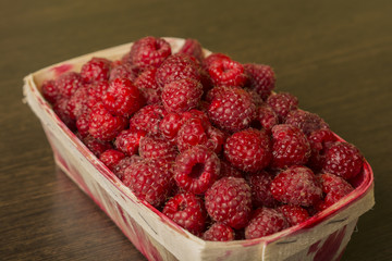 raspberry in a basket on a wooden background