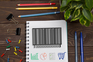 Notebook with a notes barcode product on the office table with tools. Concept with elements of infographics.