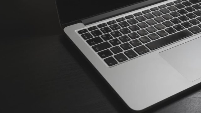 Camera Moving Above Black Desk With Silver Laptop And Phone On It