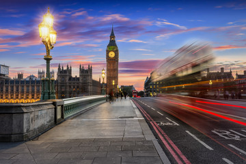 Big Ben und Westminster in London nach Sonnenuntergang mit vorbeifahrendem Bus