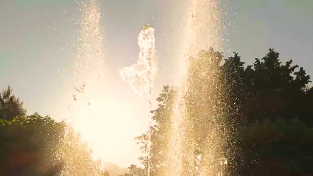 Fountain and sunlight. Water splashes in slow motion. Fundamentals of ecology.