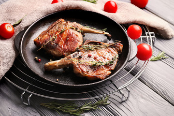 Frying pan with tasty meat on table