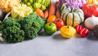 Different colored rainbow vegetables on the light grey background, copy space for text below, selective focus