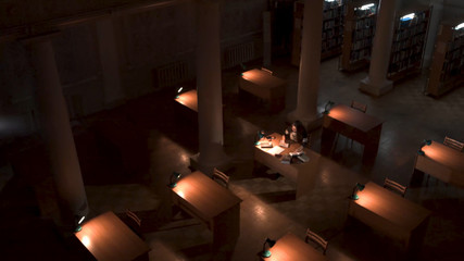 Top view of student hand writing a book with laptop at library. Girl sitting in empty library at...