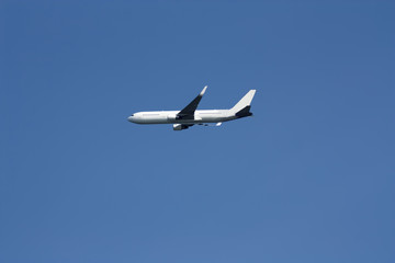 Fototapeta na wymiar Commercial Jet Flying In Clear Blue Sky
