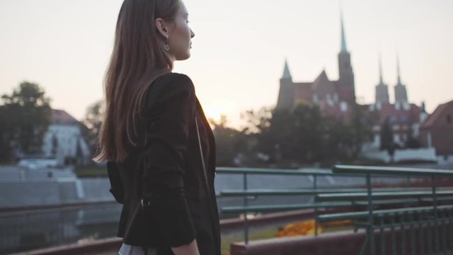 Young Businesswoman Going to Work in the Sunny Morning City. SLOW MOTION. STEADICAM Stabilized Shot. Attractive Professional Business Woman with Tablet rushing to a morning meeting. Lens Flare. 