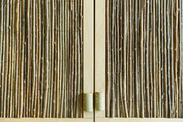 Cabinet doors, made of wood sticks. Background of different types of wood. Thin trees bunches.
