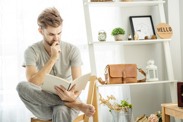 men read book in livingroom with in morning