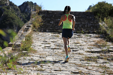  young fitness woman trail runner running on the great wall top of mountain