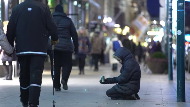 Unidentified homeless man begging on the street of European city winter