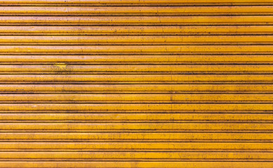 closeup old yellow rolling metal door background