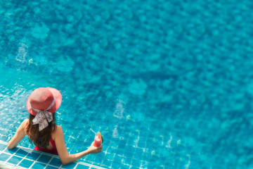 Asia woman relaxing on donut lilo in the pool water in hot sunny day. Summer holiday idyllic