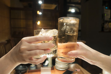 グラスで乾杯をする女性の手