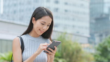 Fototapeta premium Woman using mobile phone in city