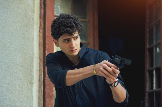 A young man holding a weapon .Man with a snub revolver