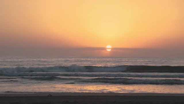 Sunrise at the beach, sea waves and sand