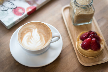 A beautiful cup of hot late art on the wooden table