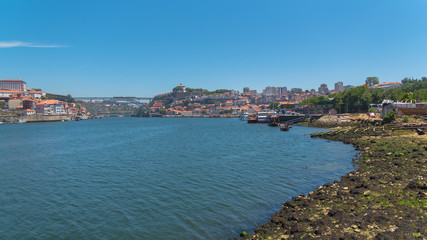Naklejka na ściany i meble Porto, Portugal, panorama of Dom Luis bridge in background, the river Douro and tiles roofs 