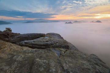 Strong sun rays make long strips in the mist.  Autumn sunny view over misty valley