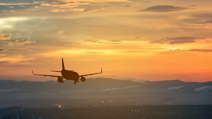 Silhouette from a landing plane that is flying to the airport.