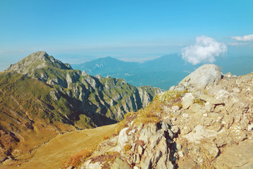 Panoramic view over the Carpatian mountains, walking paths and beautiful blue sky at the background, Bucegi natural park near Sinaia, Romania, on sunny summer day.