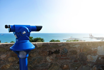 View point at Malaga fortress (Alcazaba), a blue coin telescope and a beautiful view to Mediterranean sea and a city port, Andalusia, Spain.