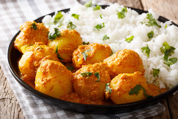Indian food: Dum aloo potatoes in a sauce with rice close-up. horizontal