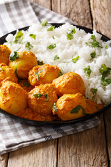 Delicious homemade Kashmiri Dum aloo potatoes with rice close-up on the table. vertical 
