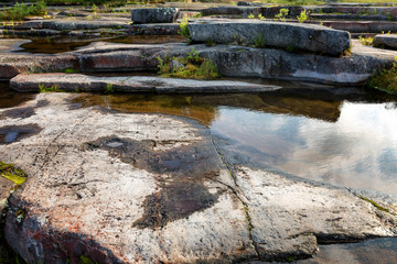 Mirror surface of water, large stones, the sky reflects