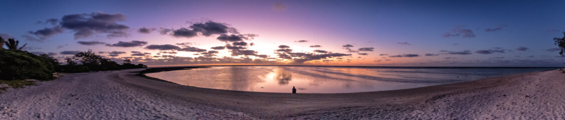 Naklejka na ściany i meble Panoramic sunrise over the coral reef on Lady Elliot Island with a person in the middle looking at the reef