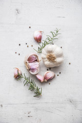 Garlic. Garlic bulbs. Fresh garlic with rosemary and pepper on white concrete board © weyo