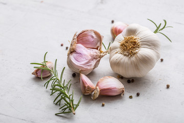 Garlic. Garlic bulbs. Fresh garlic with rosemary and pepper on white concrete board © weyo