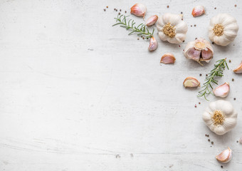 Garlic. Garlic bulbs. Fresh garlic with rosemary and pepper on white concrete board © weyo