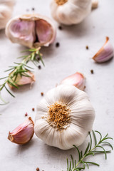 Garlic. Garlic bulbs. Fresh garlic with rosemary and pepper on white concrete board