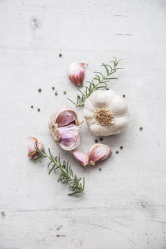 Garlic. Garlic bulbs. Fresh garlic with rosemary and pepper on white concrete board