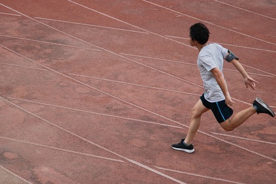 Athletic Asian Runner Sprinter Crossing The Finish Line.