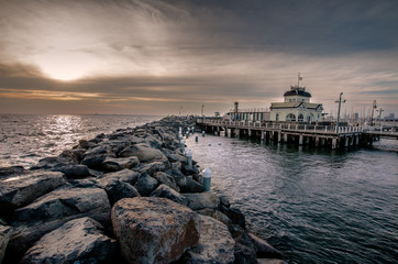 St kilda Pier and kiosk in Melbourne Australia at dusk on a cloudy day.