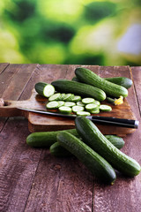 Fresh and sliced cucumbers. Sliced cucumbers on a cutting board.