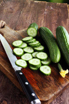 Fresh and sliced cucumbers. Sliced cucumbers on a cutting board.