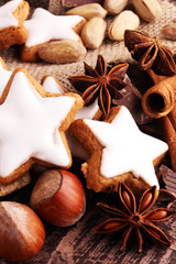 Christmas cookies and spices on brown wooden background.