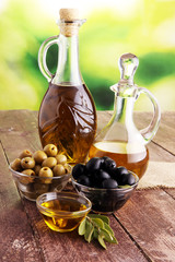 Olive oil and olive branch on the wooden table