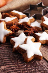 Christmas cookies and spices on brown wooden background.