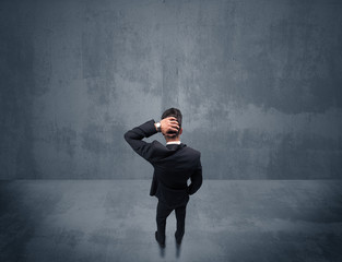 Businessman standing in front of urban wall