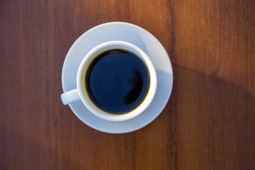 Cup of coffee on wooden table. Top view