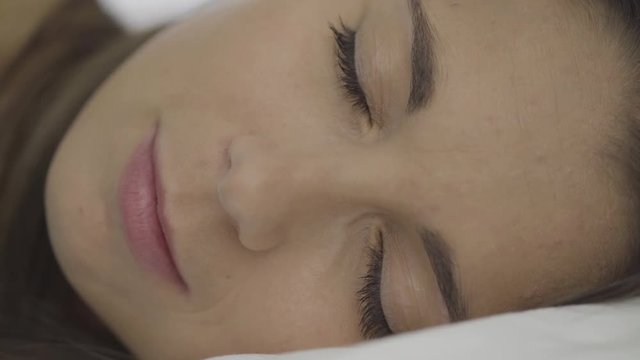 4k video detail only face of woman sleeping and waking up opening eyes
