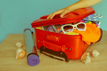 Woman packing suitcase. Suitcase with different things prepared for travel