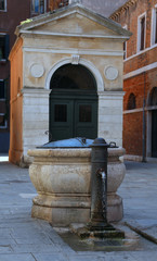 ancient stone well in a square of a European city